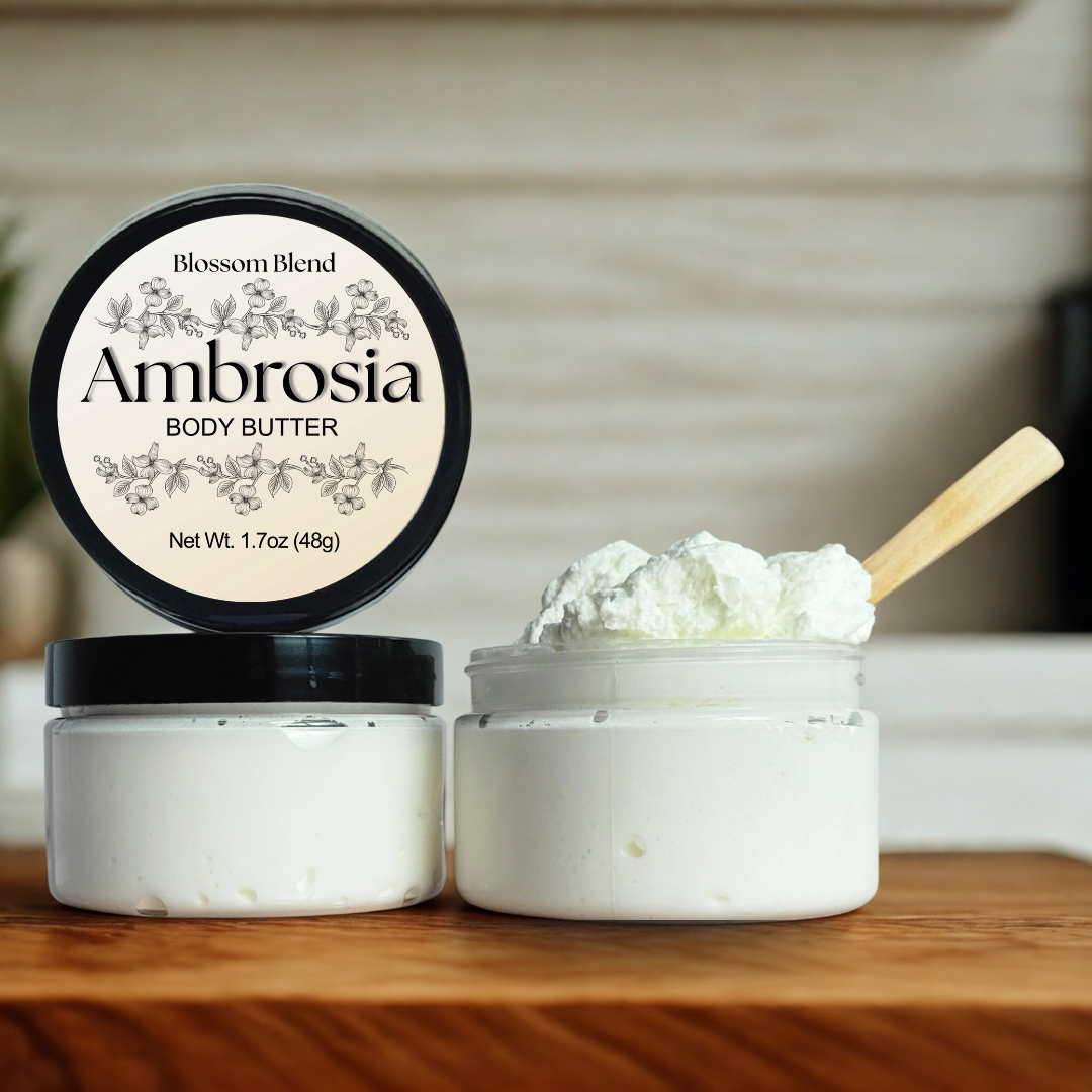 Ambrosia body butter with a wooden spoon on a wooden surface