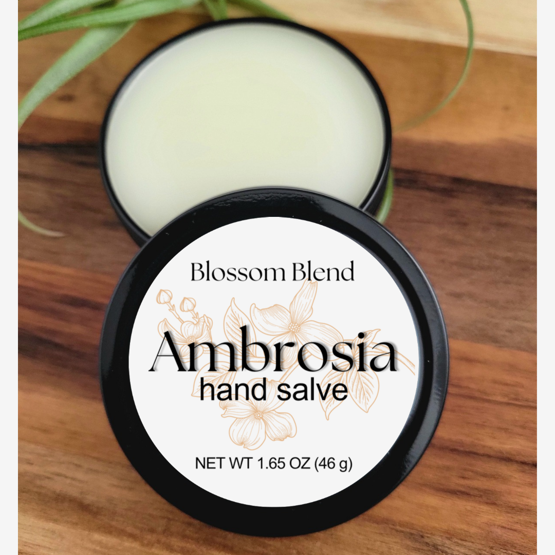 Ambrosia hand salve container with 'Blossom Blend' branding on a wooden surface.