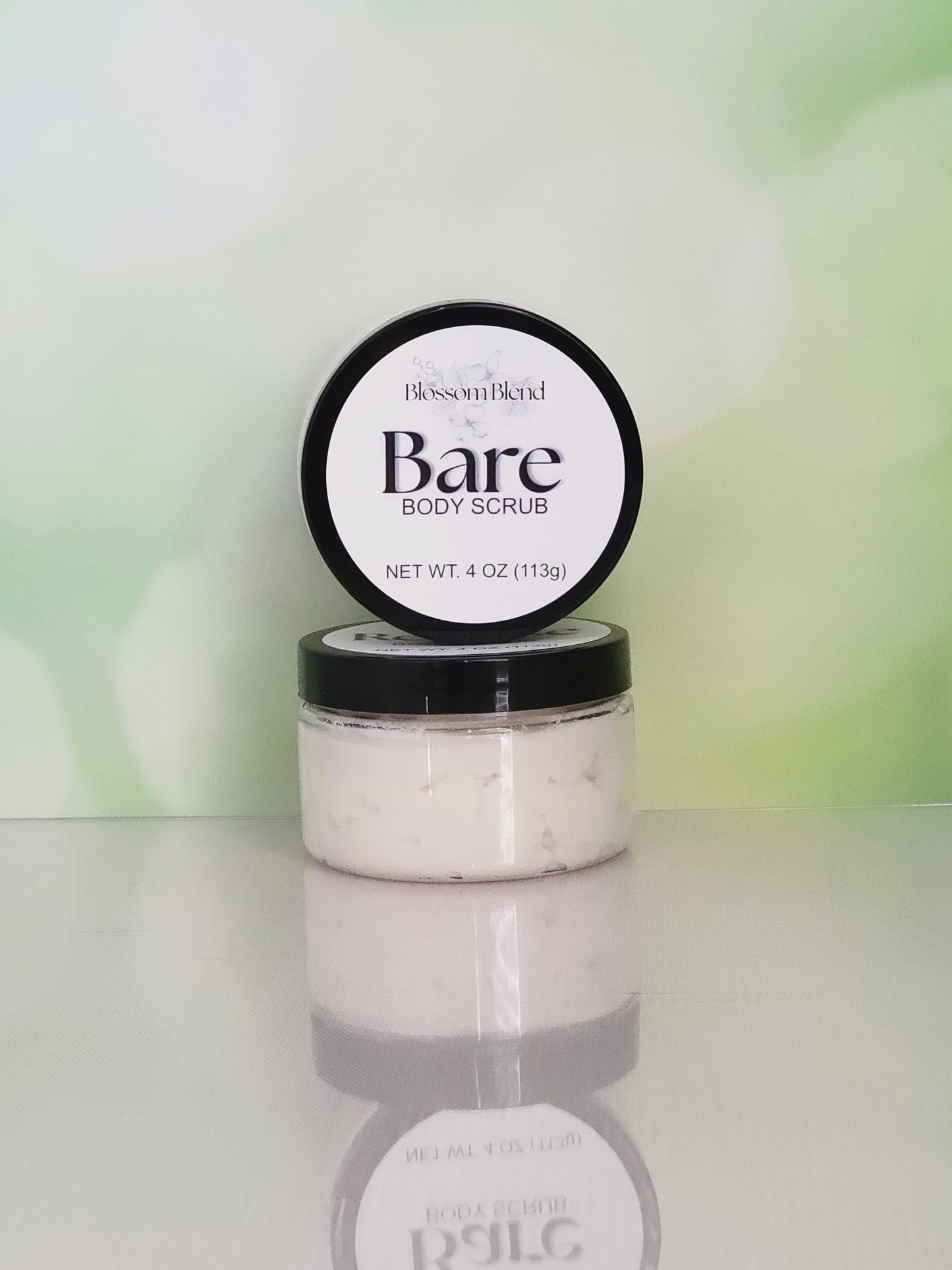 Jar of Bare Body Scrub with a blurred green background