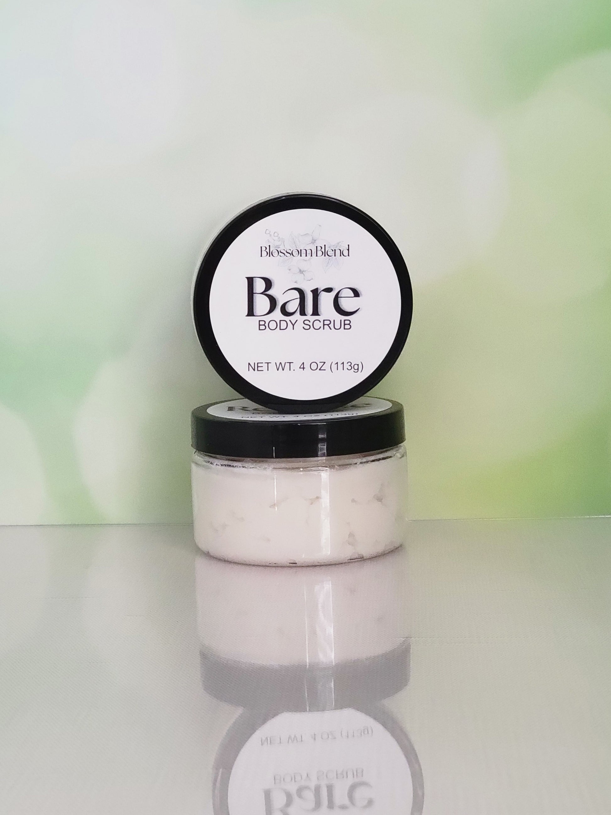 Jar of Bare Body Scrub with a blurred green background