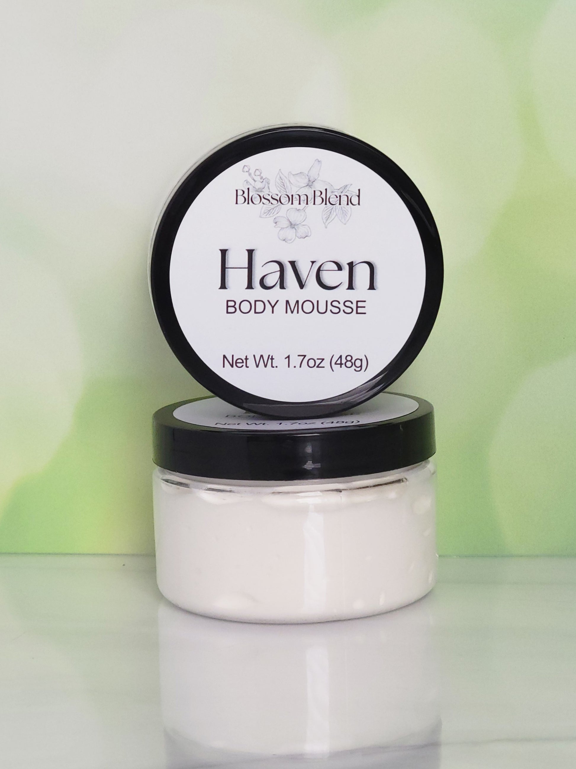 Jar of Haven Body Mousse with a black lid on a light green background