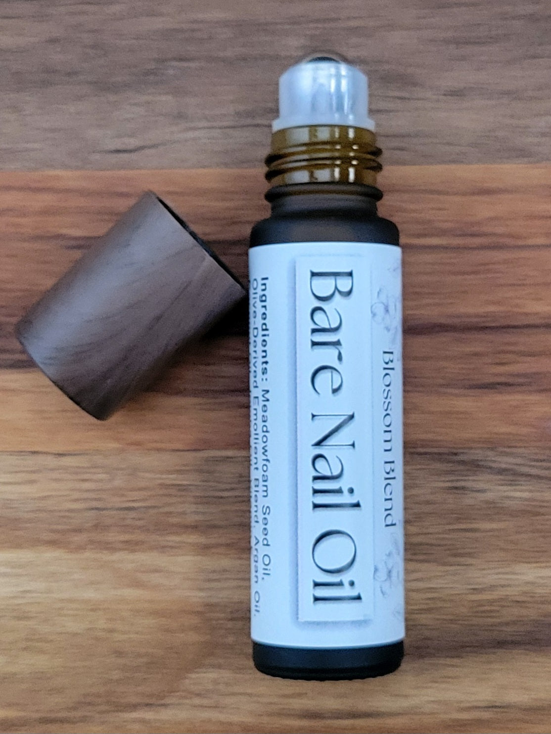 Bottle of Bare Nail Oil on a wooden surface