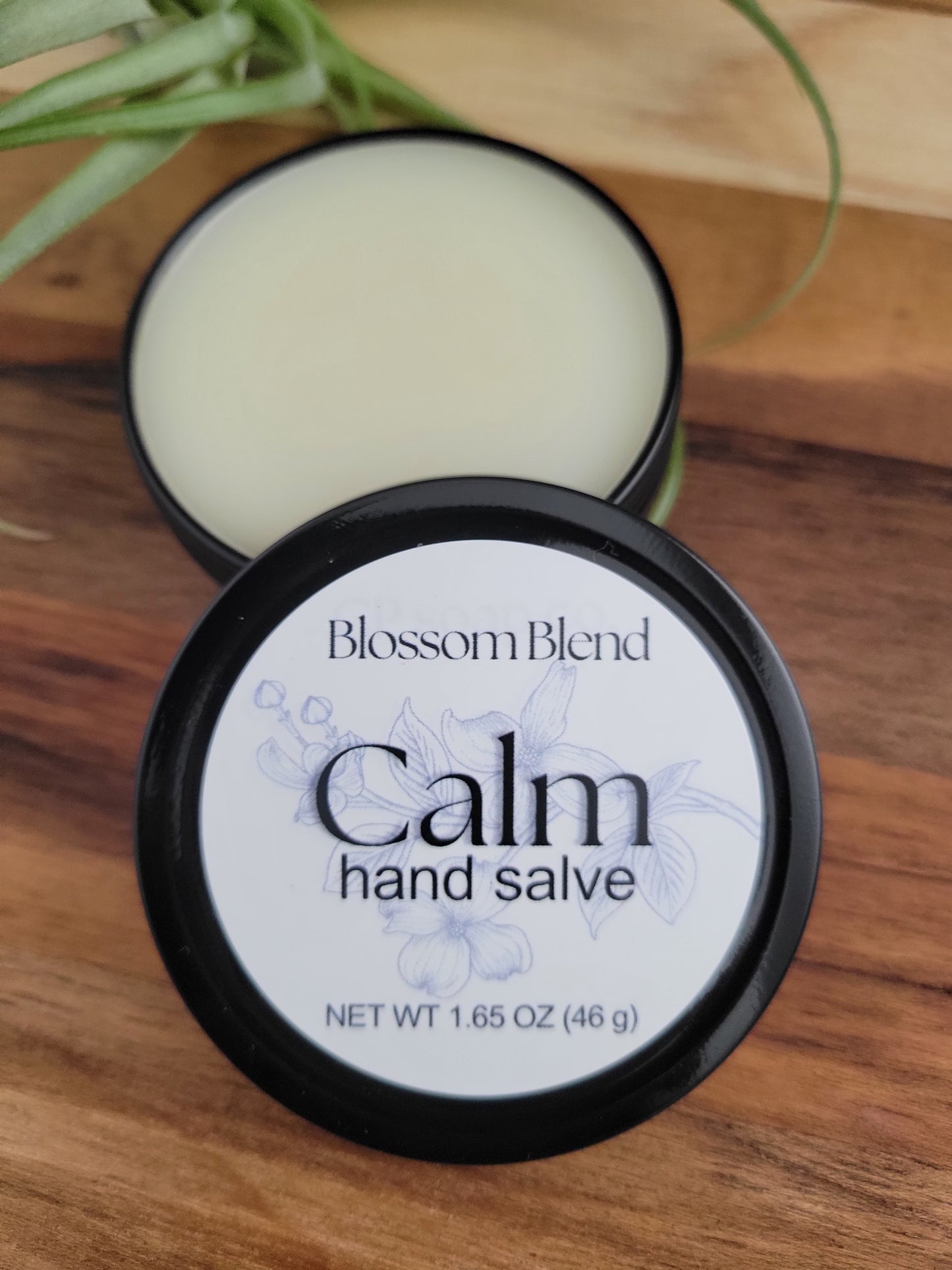 Blossom Blend Calm hand salve jar on a wooden surface
