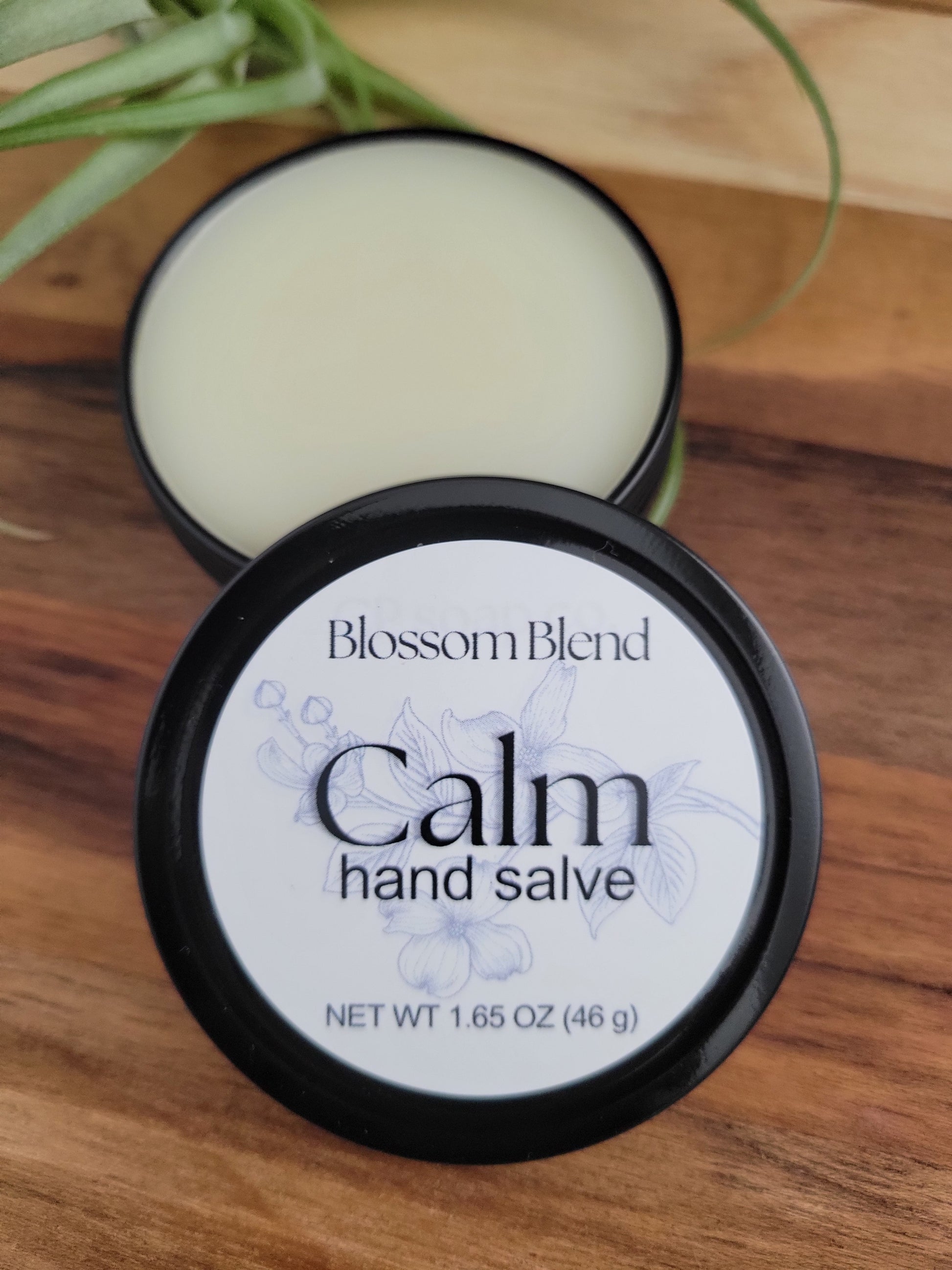 Blossom Blend Calm hand salve jar on a wooden surface