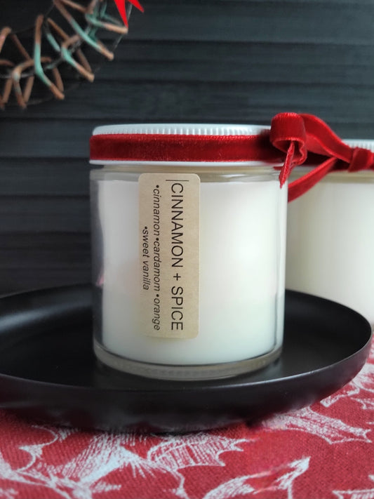 Candle with a red lid and label on a dark surface