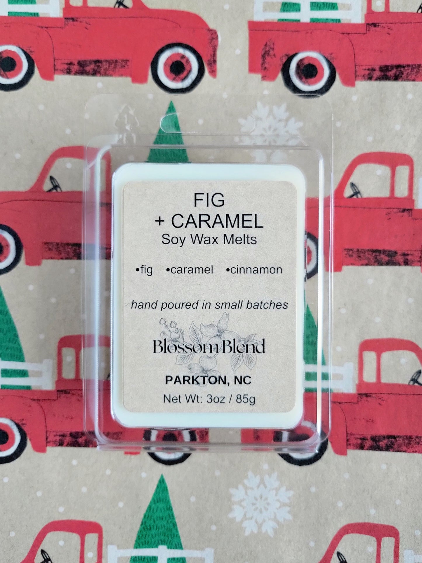 Fig + Caramel soy wax melts packaging with a festive truck and tree pattern in the background.