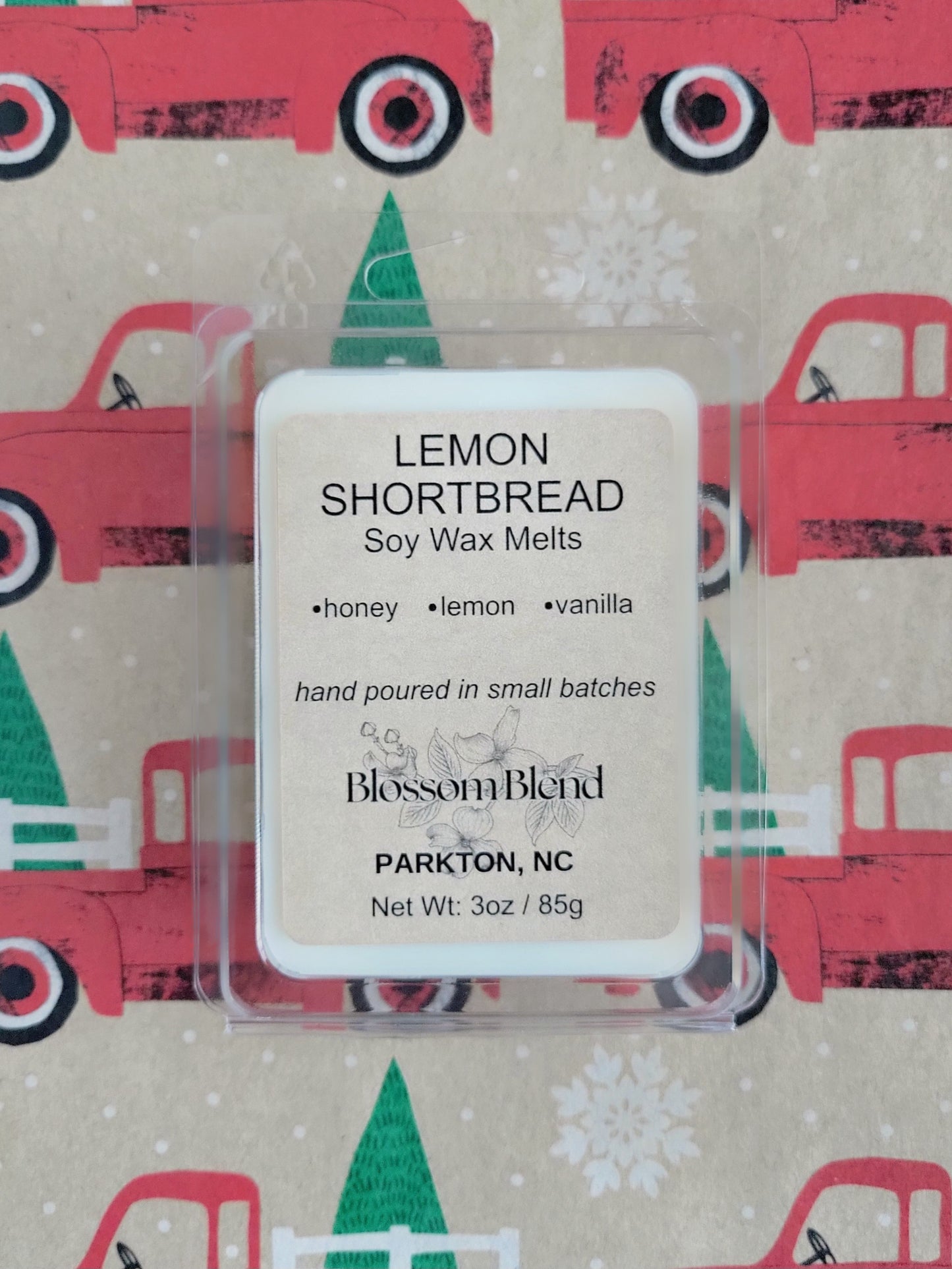 Lemon shortbread soy wax melt packaging with 'Blossom Blend' branding on a festive background.