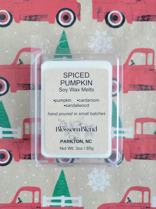 Spiced Pumpkin soy wax melts packaging with a festive background featuring red trucks and green trees.