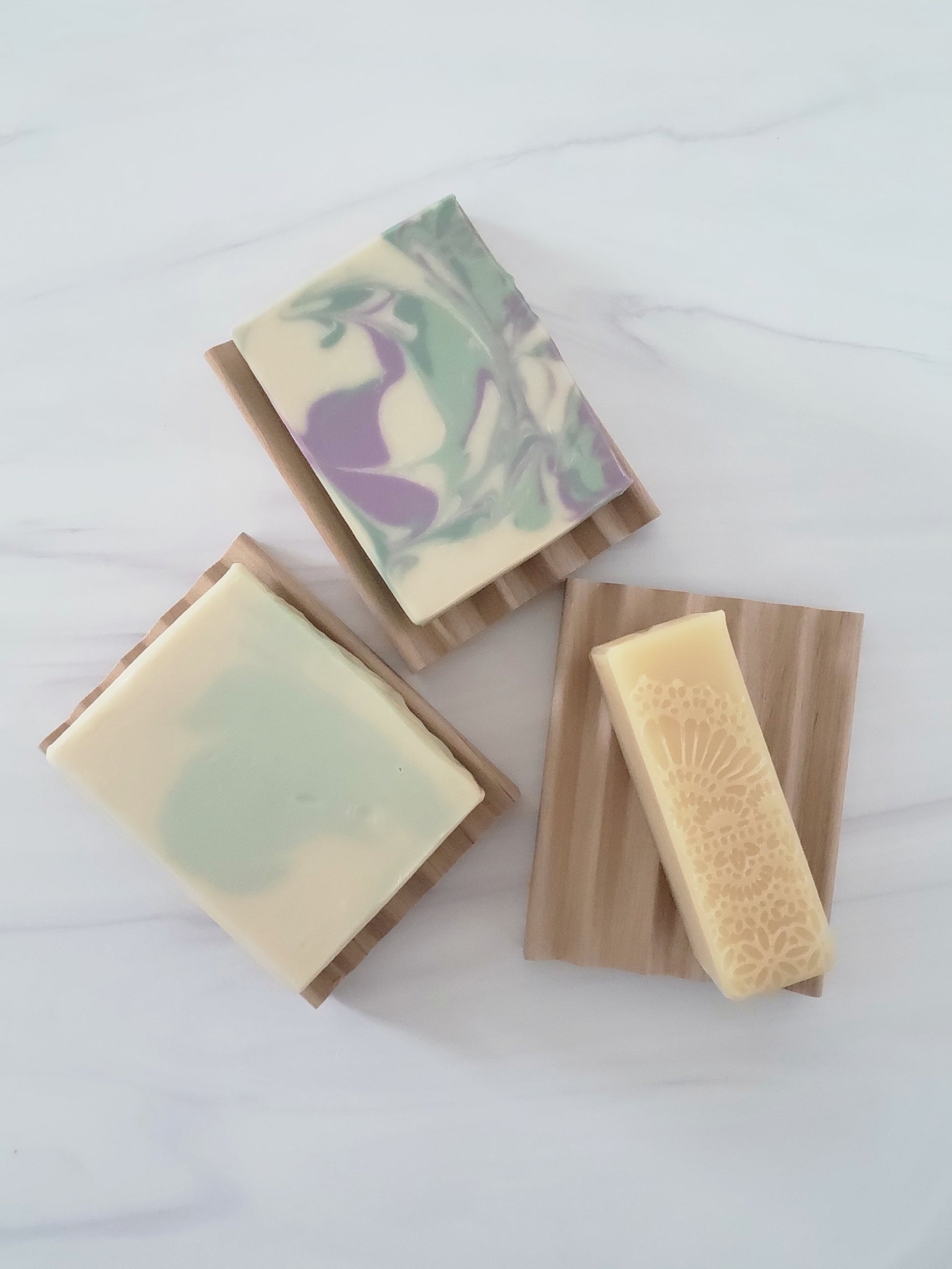 Top view of three poplar wood soap dishes with cold process soap